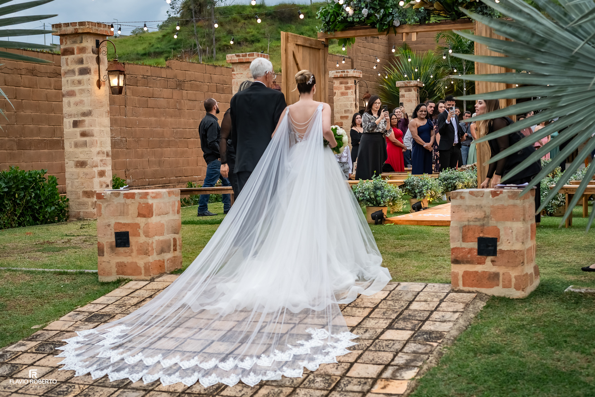 Noiva entrando para a cerimônia de casamento ao ar livre no Espaço Aloha em Cruzeiro/SP.