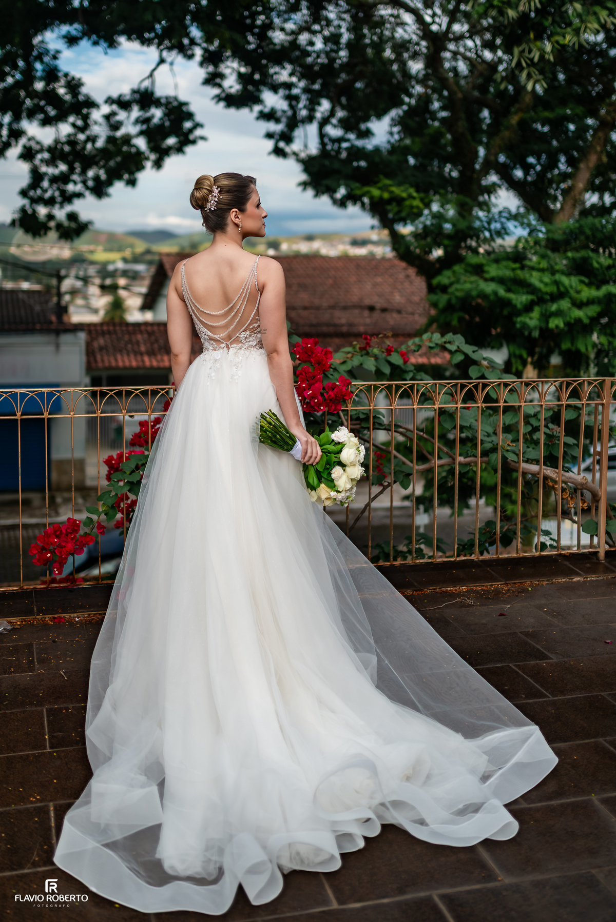 Vestido da noiva Júlia com detalhes nas costas antes da cerimônia de casamento no Espaço Aloha em Cruzeiro/SP.