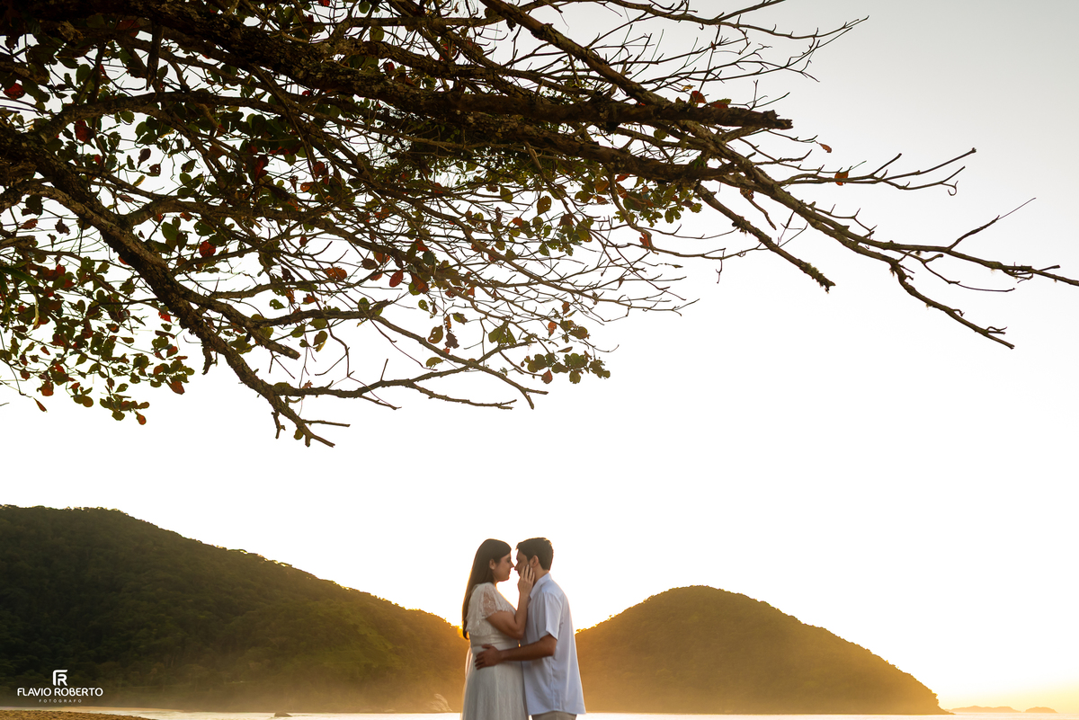 Casal em contraluz durante o nascer do sol na Praia Vermelha do Norte, em Ubatuba.
