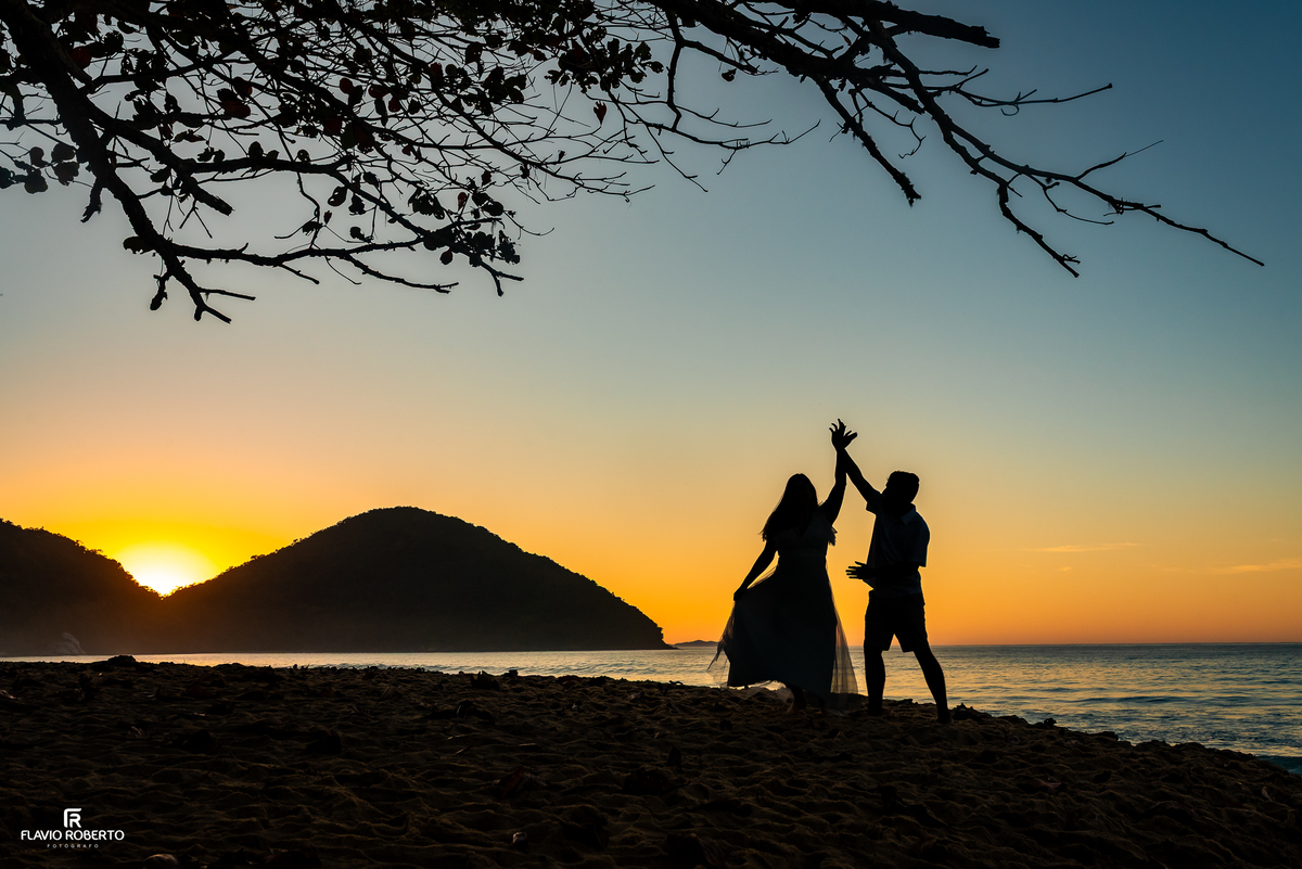Natália e Kauan brincando na areia durante ensaio ao nascer do sol em Ubatuba.