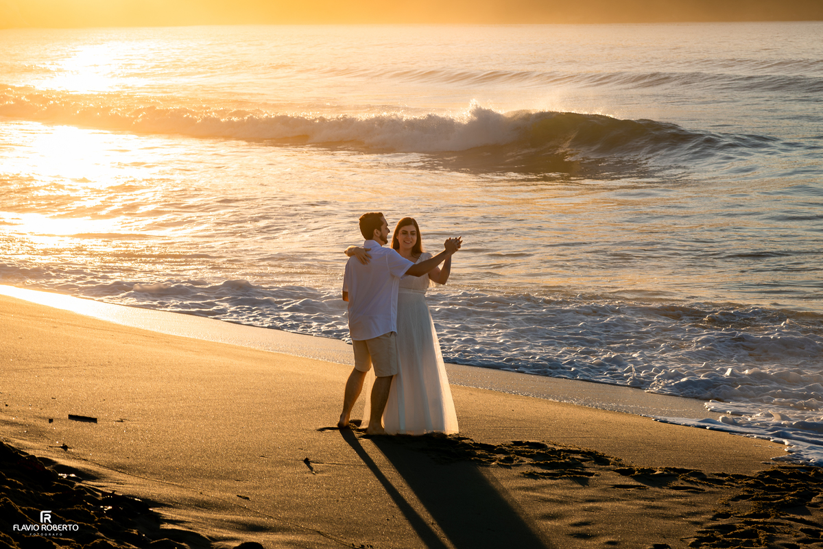 Natália e Kauan dançando na areia durante o nascer do sol na Praia Vermelha do Norte.