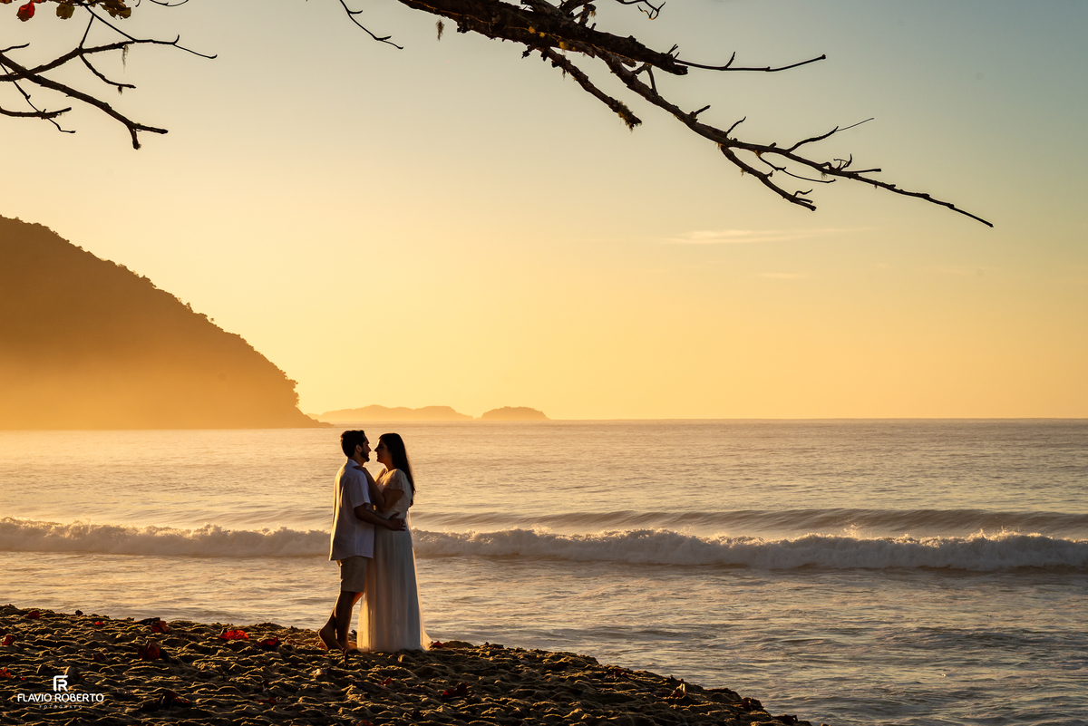 Casal em ensaio romântico na Praia Vermelha do Norte com a luz dourada do amanhecer.
