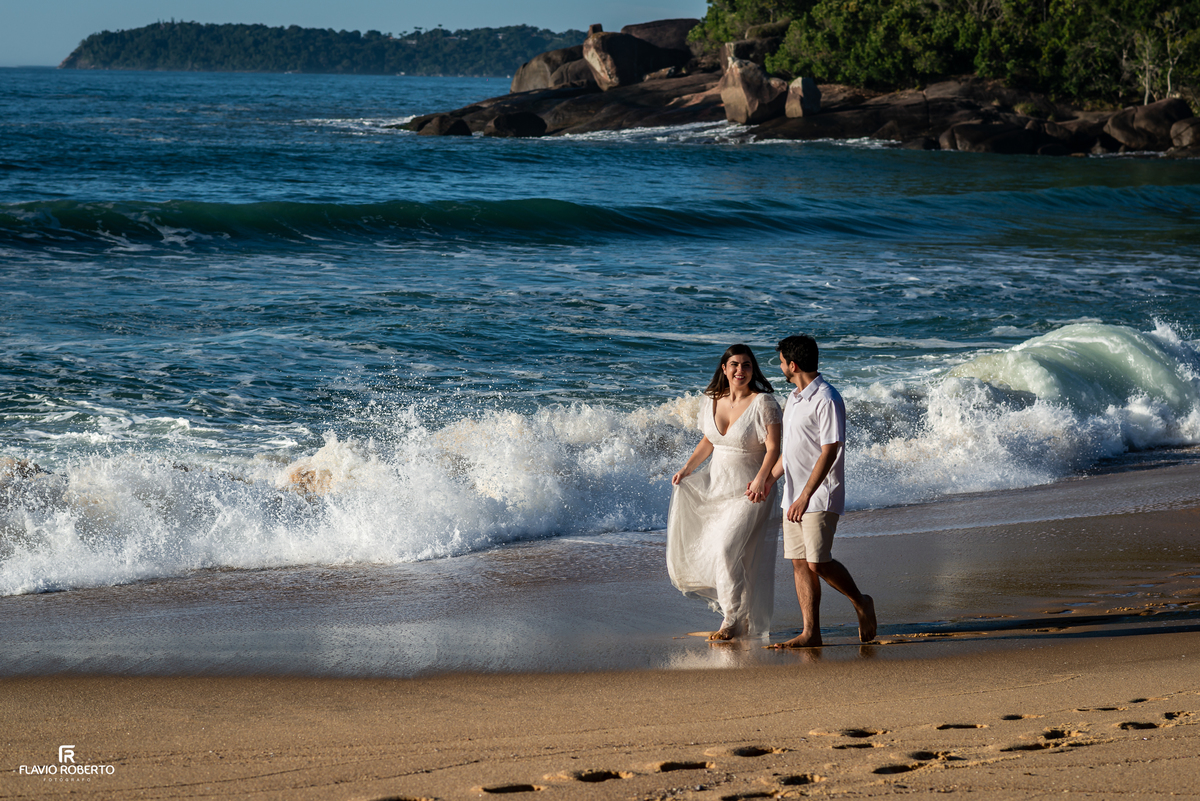 Casal caminhando à beira-mar durante ensaio pré wedding na Praia Vermelha do Norte, em Ubatuba.