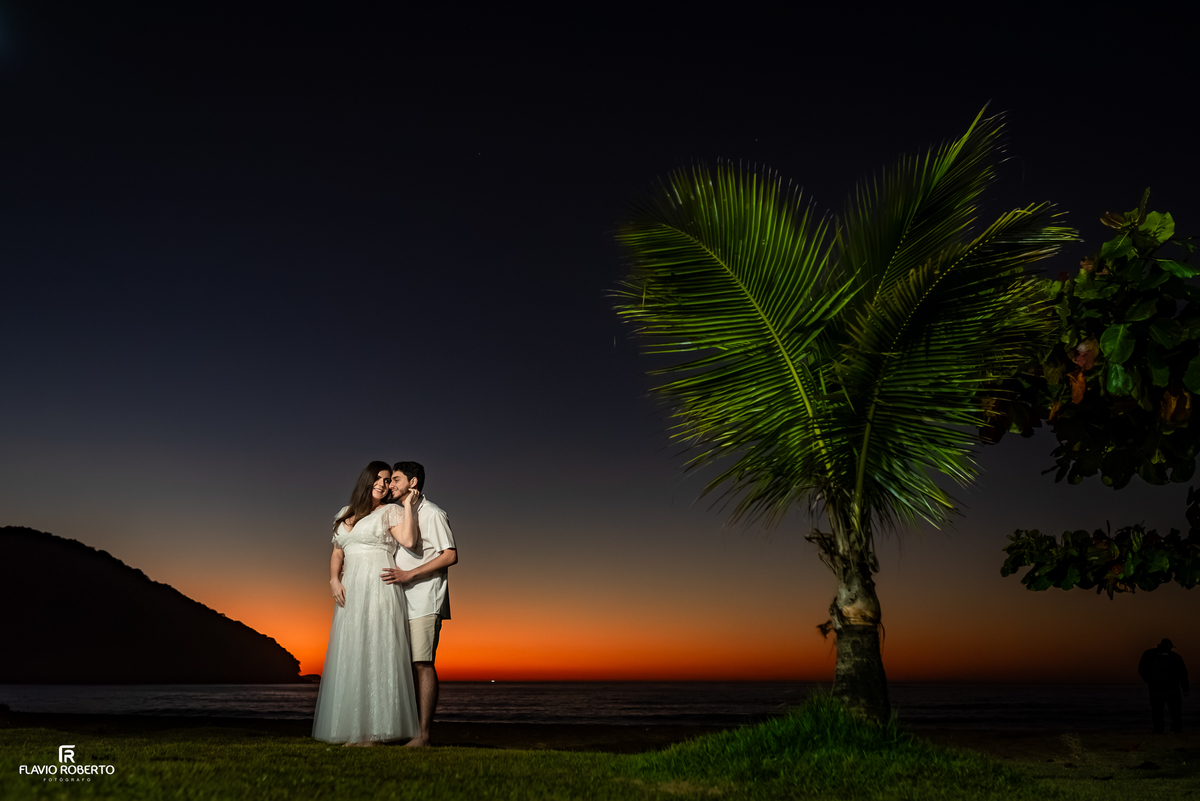 Natália e Kauan durante ensaio ao amanhecer na Praia Vermelha do Norte, em Ubatuba, com o céu antes do nascer do sol.