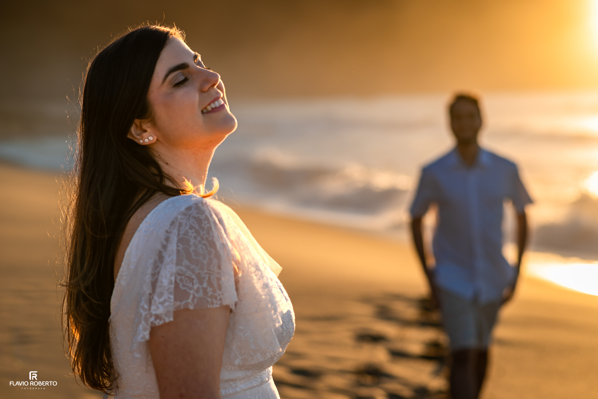 Retrato espontâneo de Natália sorrindo durante ensaio ao nascer do sol em Ubatuba.