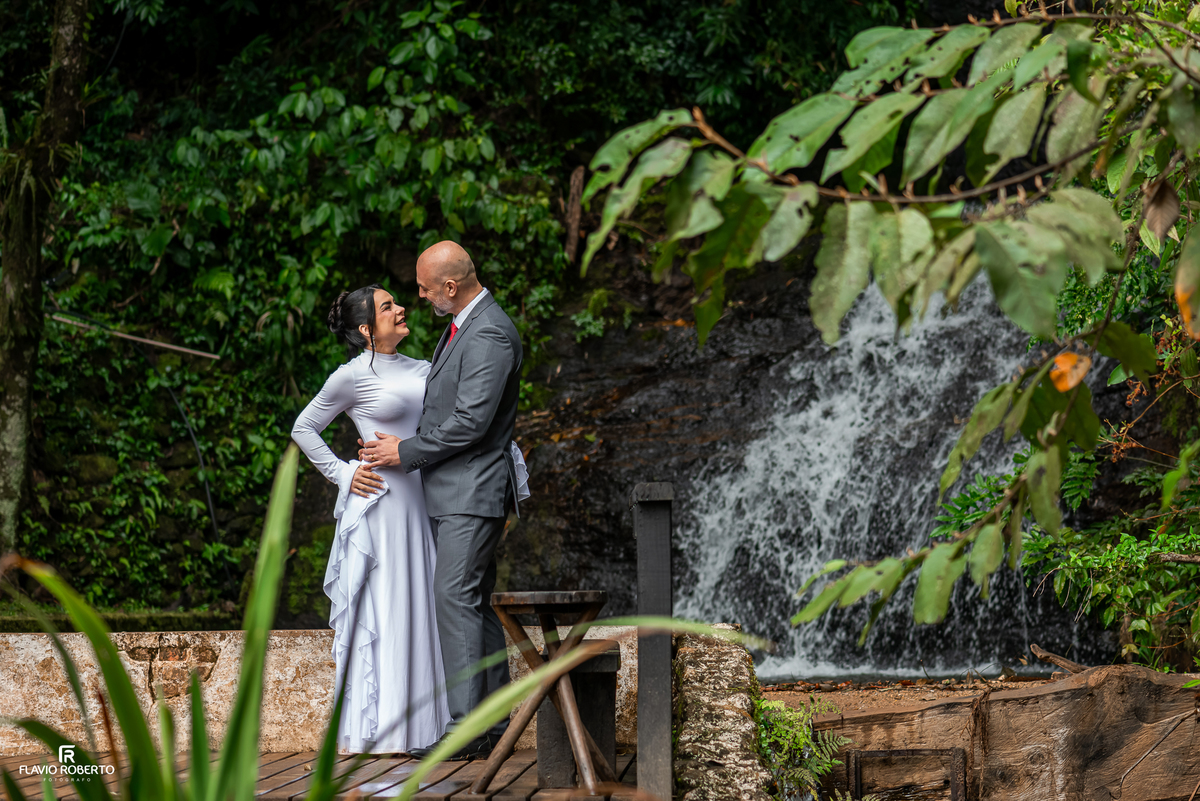 Casal fotografado diante da cachoeira do Restaurante Arco Íris em Santo Antônio do Pinhal.