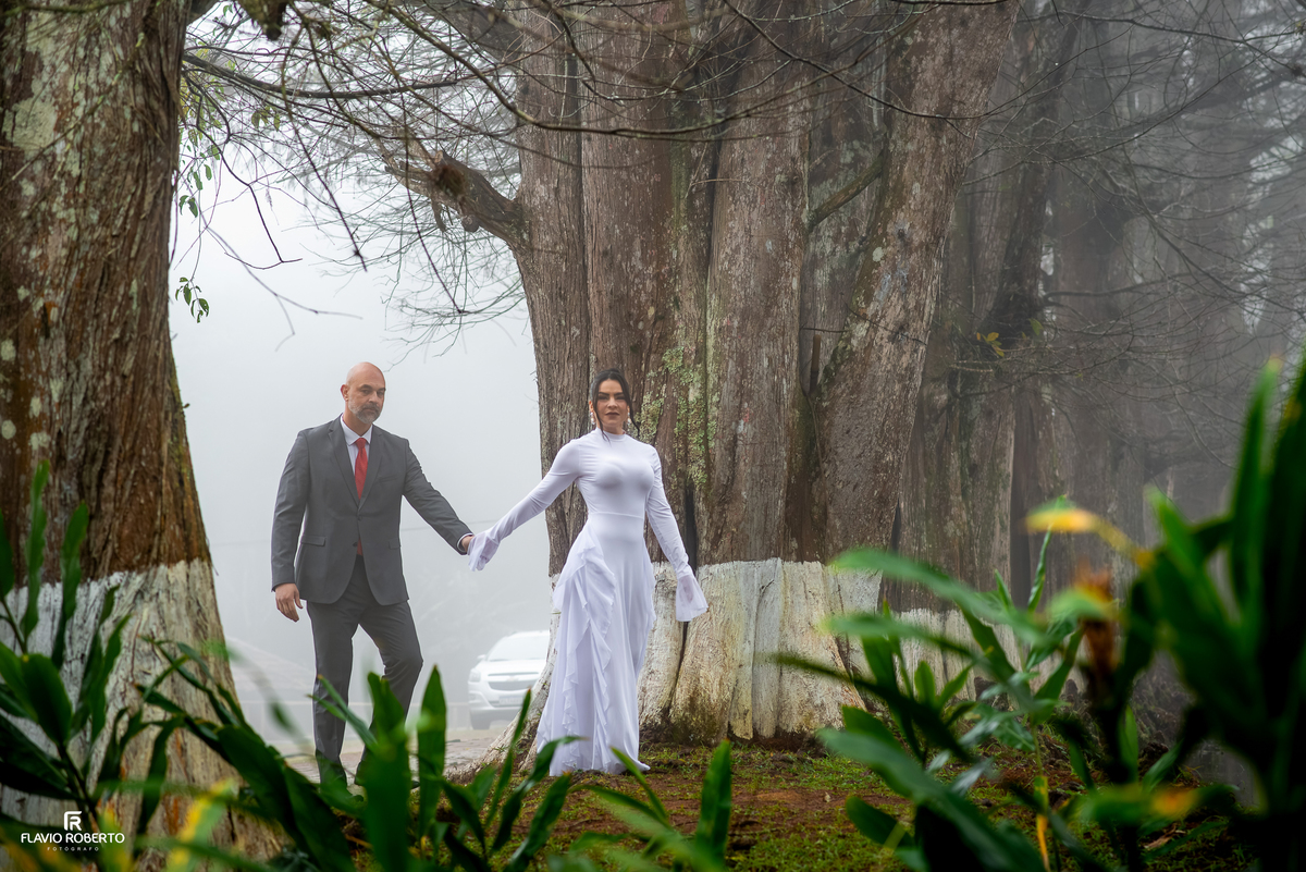 Casal caminhando entre as árvores durante ensaio pré wedding no Restaurante Arco Íris em Santo Antônio do Pinhal.