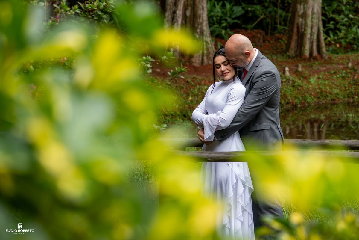 Casal entre flores e jardins durante ensaio pré wedding no Restaurante Arco Íris.