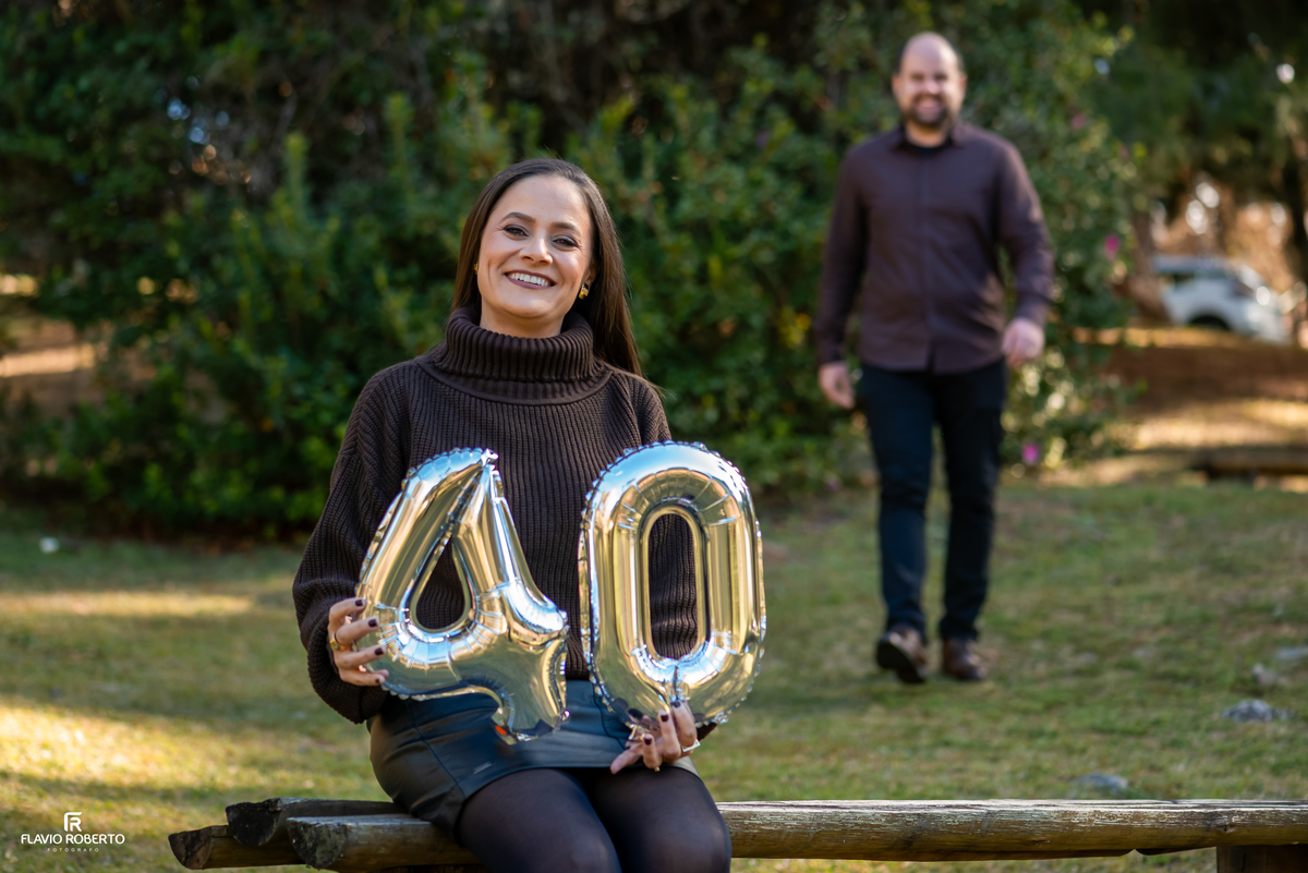 Marcilene celebra seus 40 anos durante ensaio de casal no Horto Florestal de Campos do Jordão enquanto Paulo se aproxima ao fundo.
