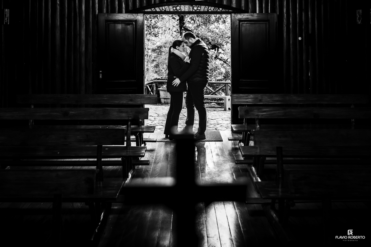 Fotografia em preto e branco do casal na entrada da capela do Horto Florestal de Campos do Jordão.