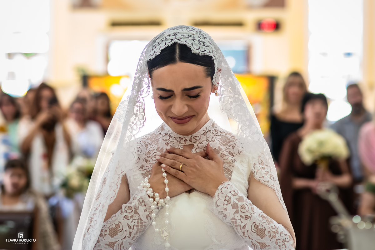Noiva emocionada durante momento de fé na cerimônia de casamento
