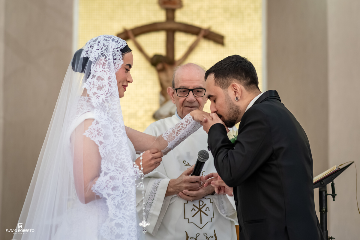 Noivo beija a mão da noiva durante a cerimônia de casamento