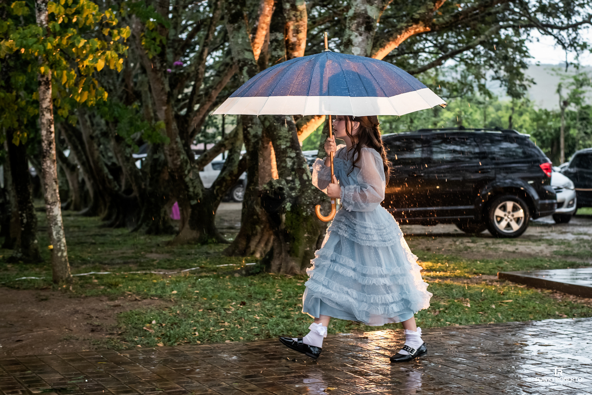 Convidada caminhando com guarda-chuva durante a chuva no Recanto do Bosque