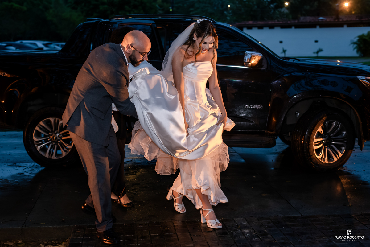 Raissa chegando sob a chuva para sua cerimônia de casamento no Recanto do Bosque