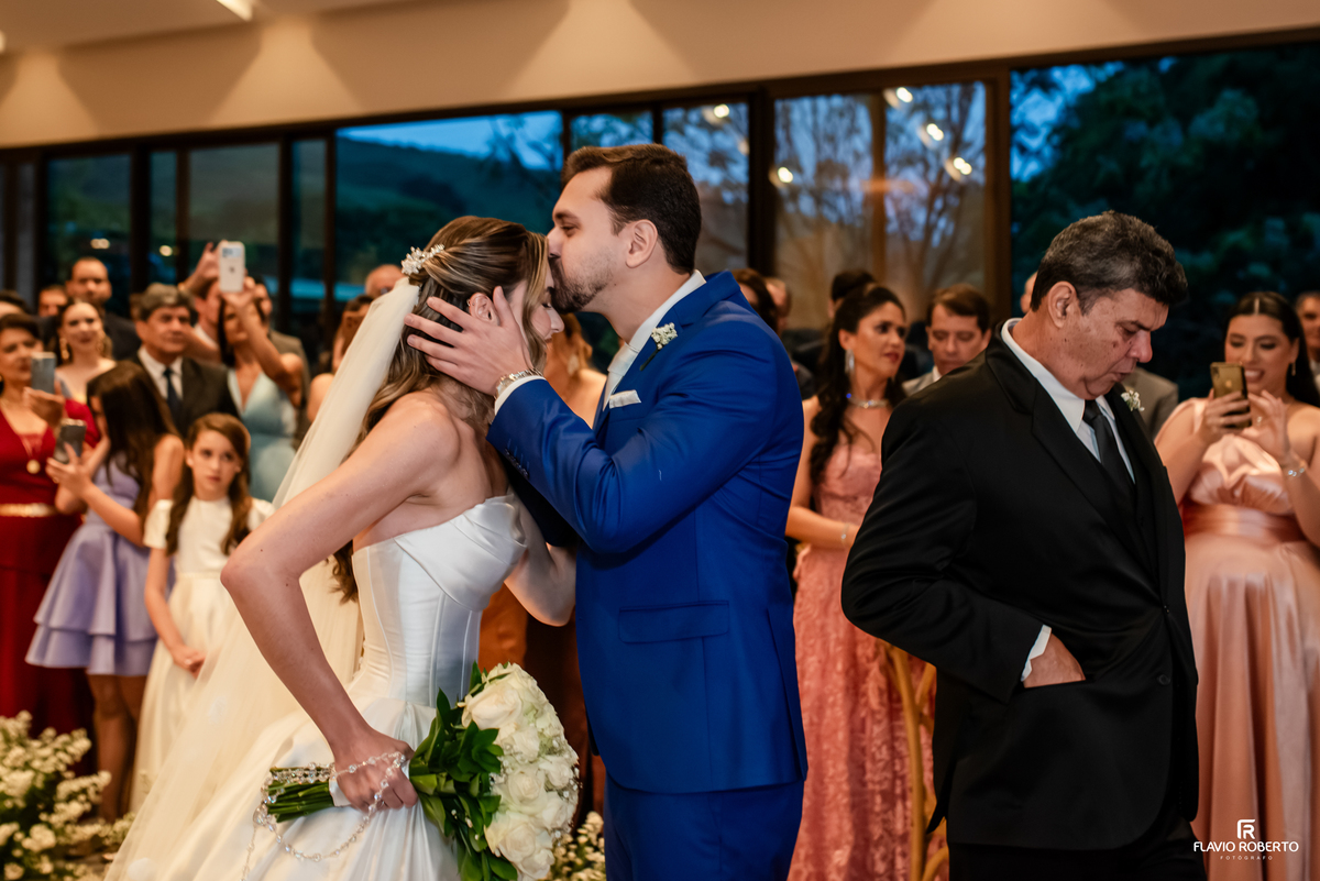 Noivo beija a testa da noiva durante cerimônia de casamento no Recanto do Bosque, em Guaratinguetá.