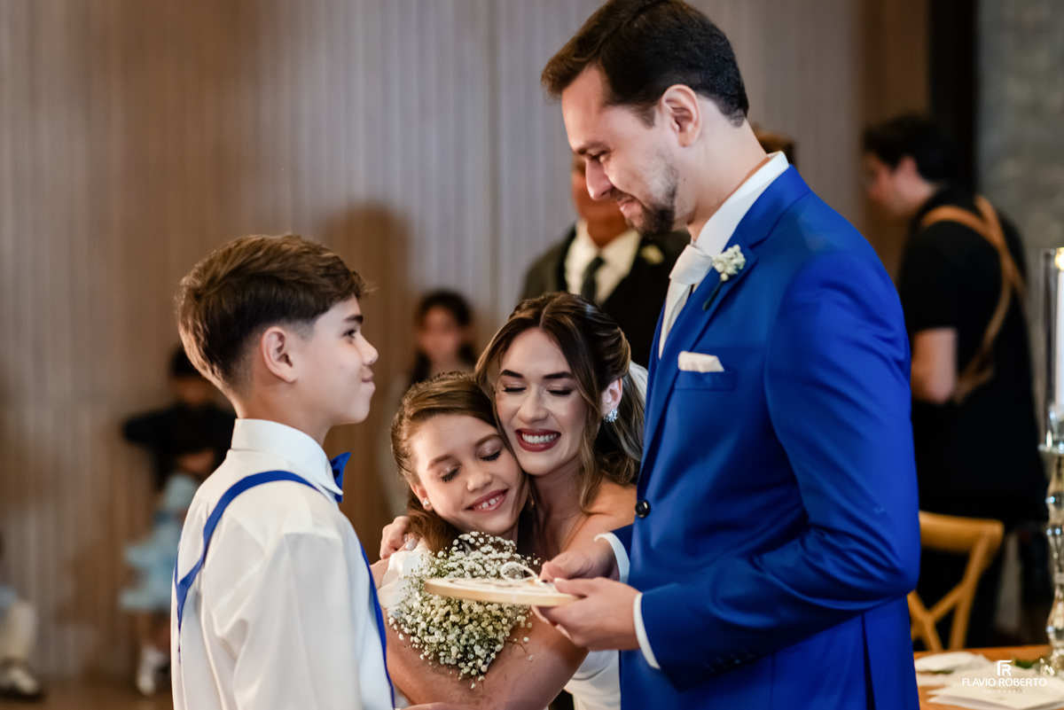 Noiva abraça uma criança durante momento emocionante da cerimônia de casamento no Recanto do Bosque.