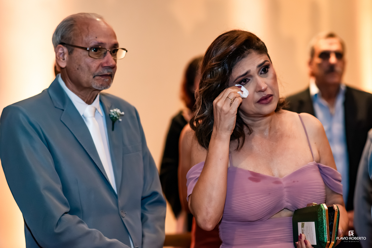 Convidada emocionada enxuga as lágrimas durante cerimônia de casamento no Recanto do Bosque, em Guaratinguetá.