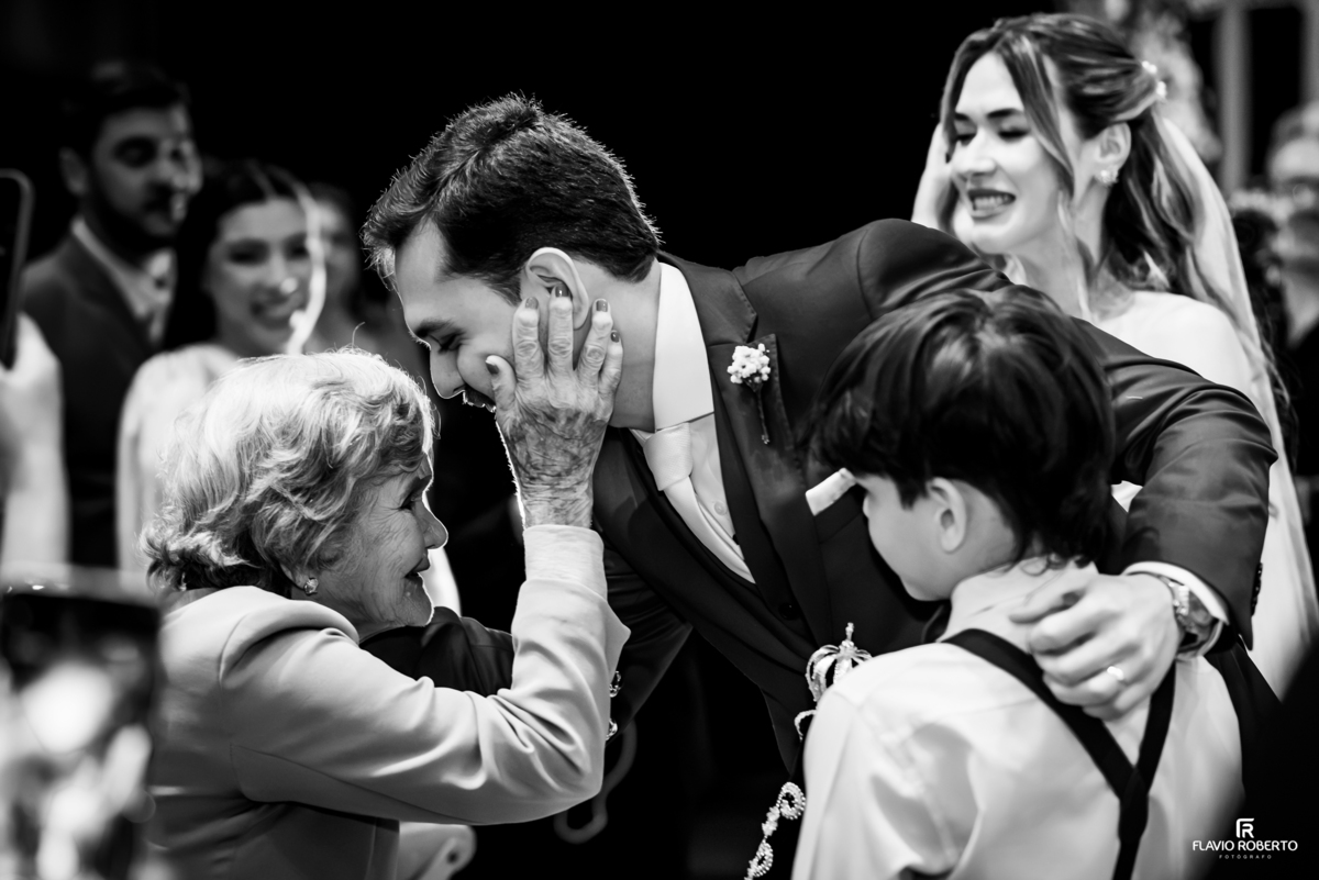 Avó acaricia o rosto do noivo em momento emocionante após cerimônia de casamento em Guaratinguetá.