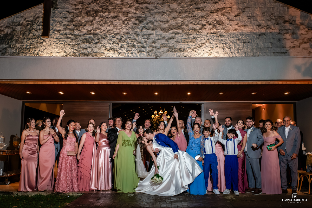 Noivos se beijam diante de familiares e convidados após cerimônia de casamento no Recanto do Bosque.