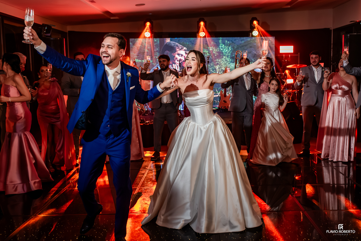 Noivos e convidados brindam juntos na pista de dança durante festa de casamento em Guaratinguetá.