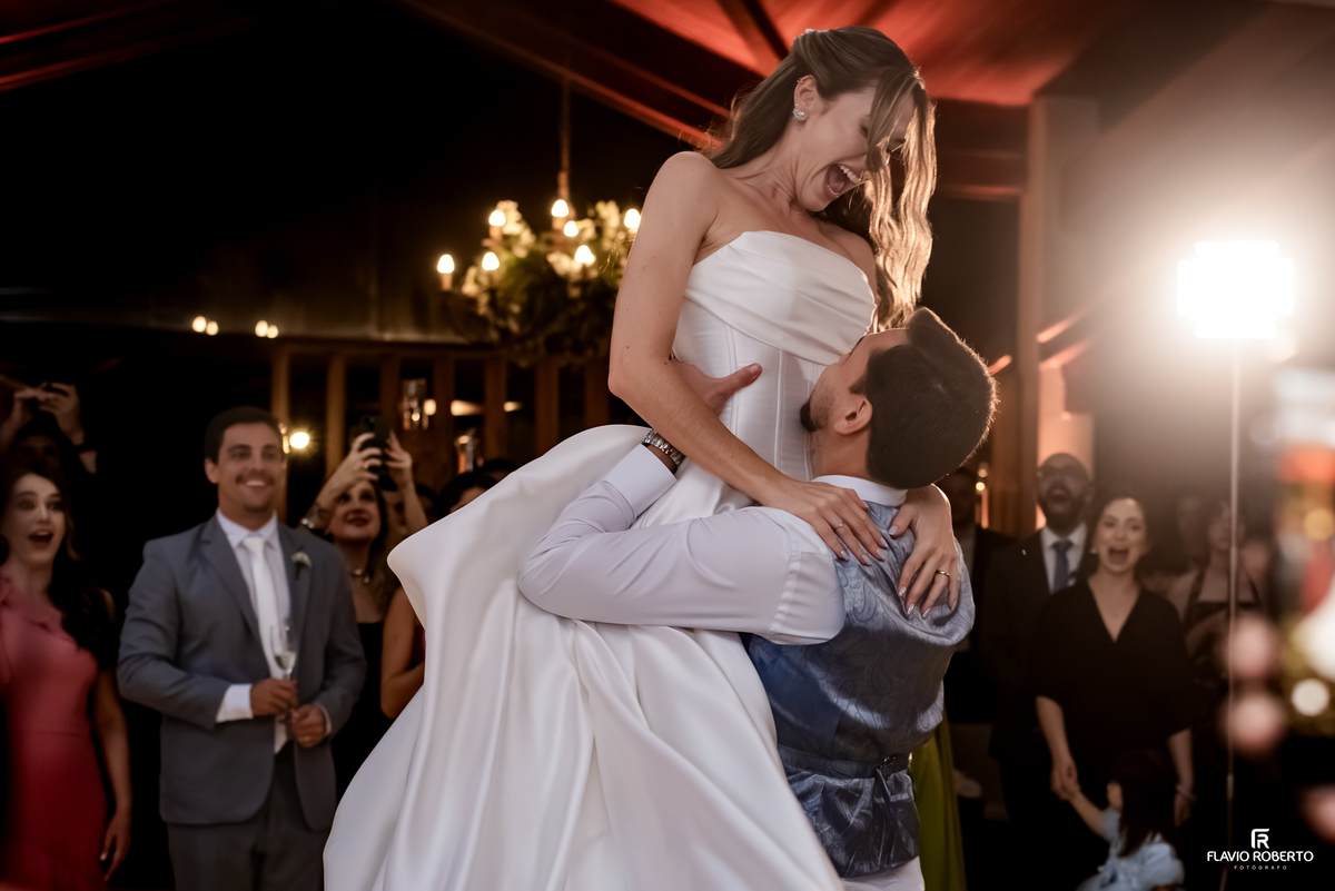 Noivo levanta a noiva durante momento divertido na pista de dança da festa de casamento em Guaratinguetá.