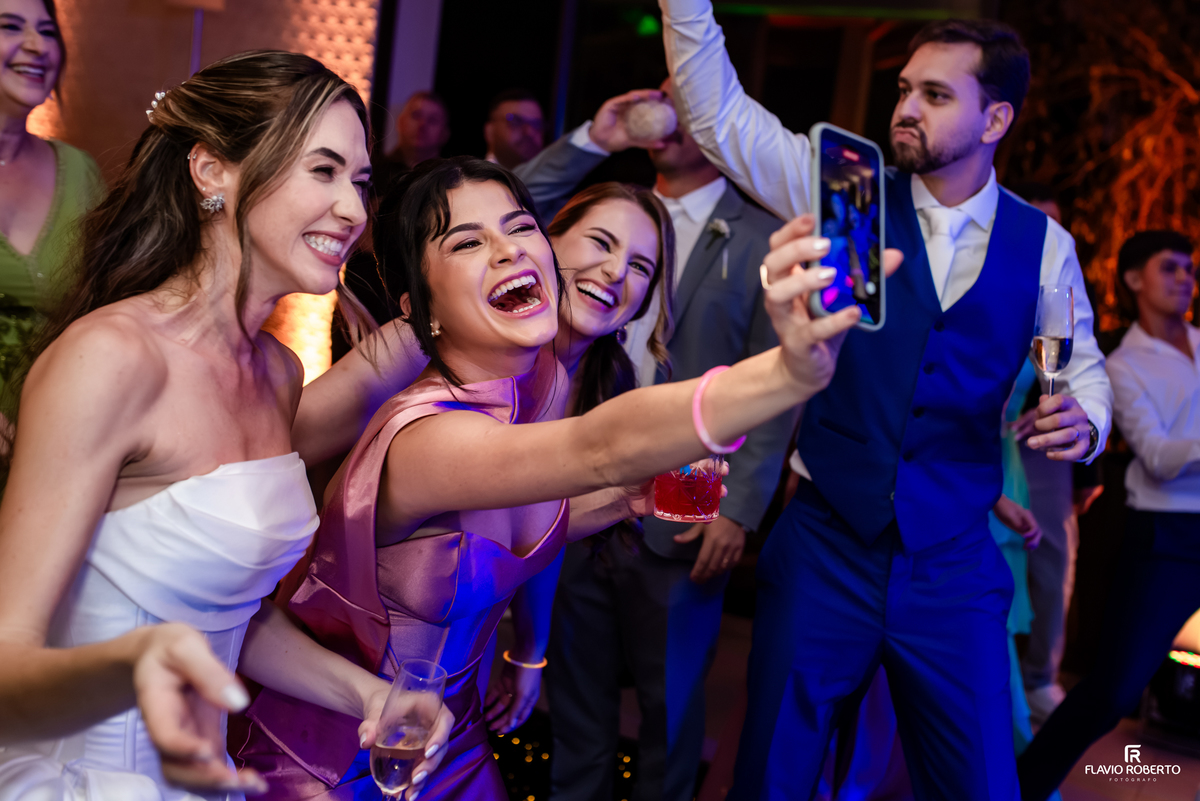 Noiva e convidadas fazem selfie durante pista de dança animada na festa de casamento em Guaratinguetá.
