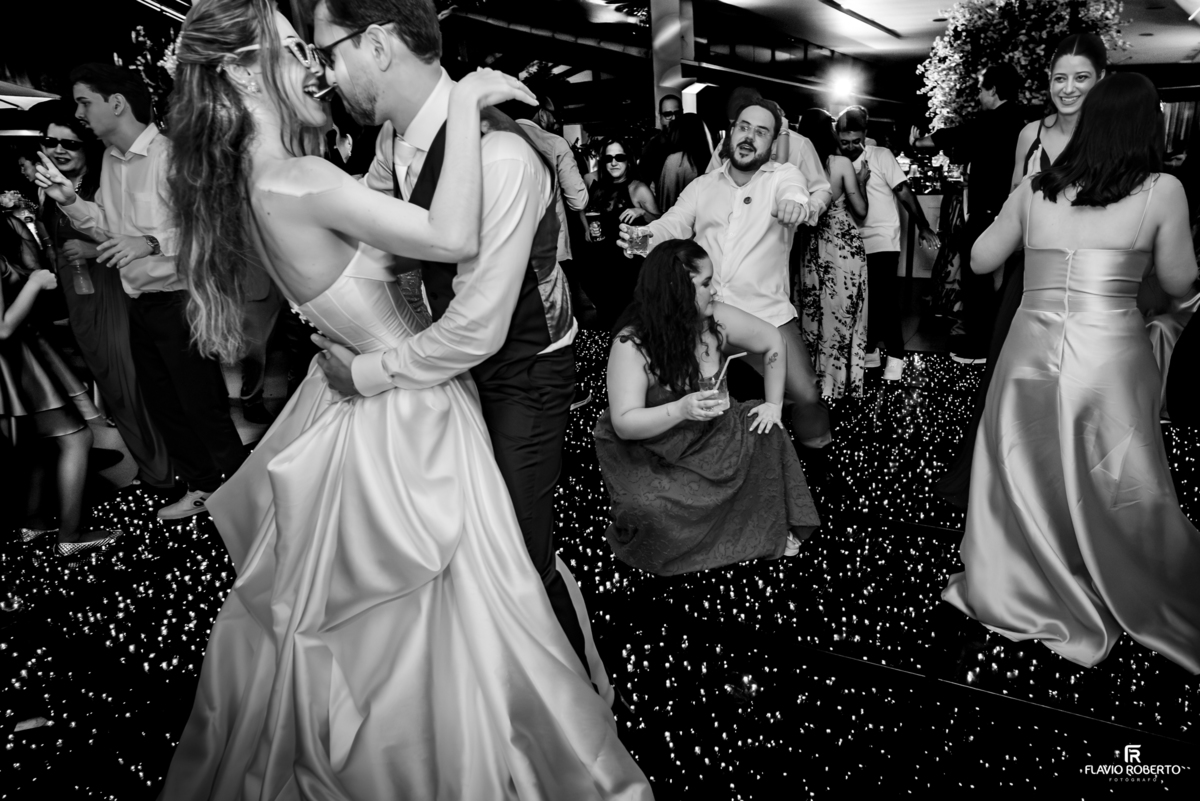 Noivos dançando juntos na pista iluminada durante festa de casamento no Recanto do Bosque