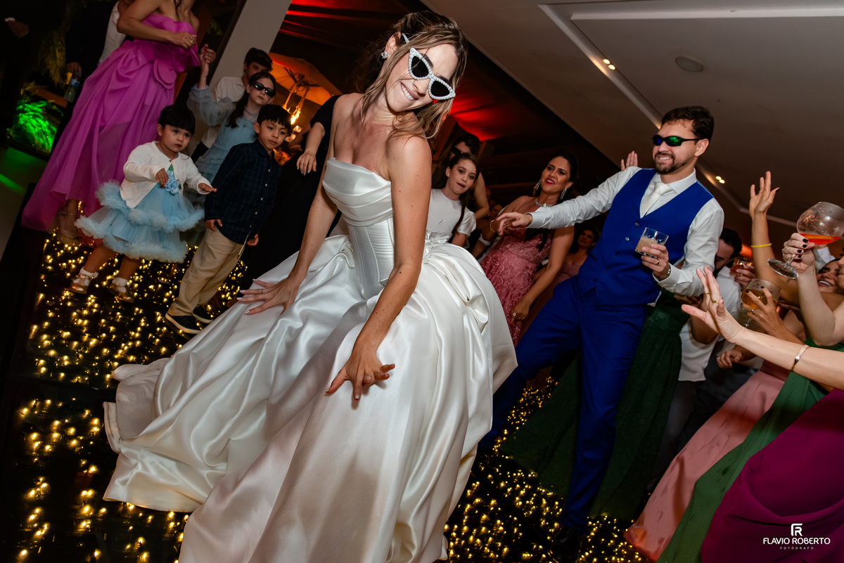 Noiva dançando na pista com noivo e convidados durante casamento no Recanto do Bosque