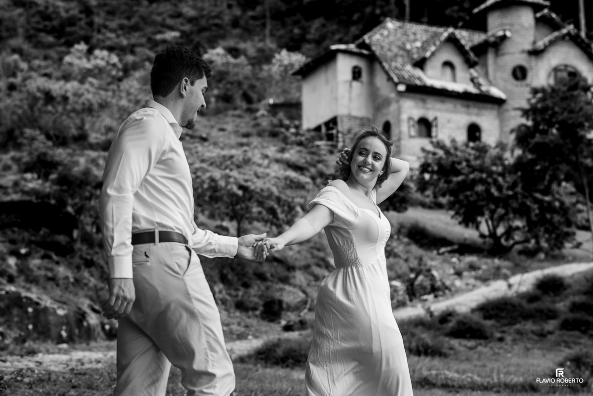 Ivanna e Luis Gustavo de mãos dadas com o Castelo de Pedra ao fundo em Itamonte, Minas Gerais