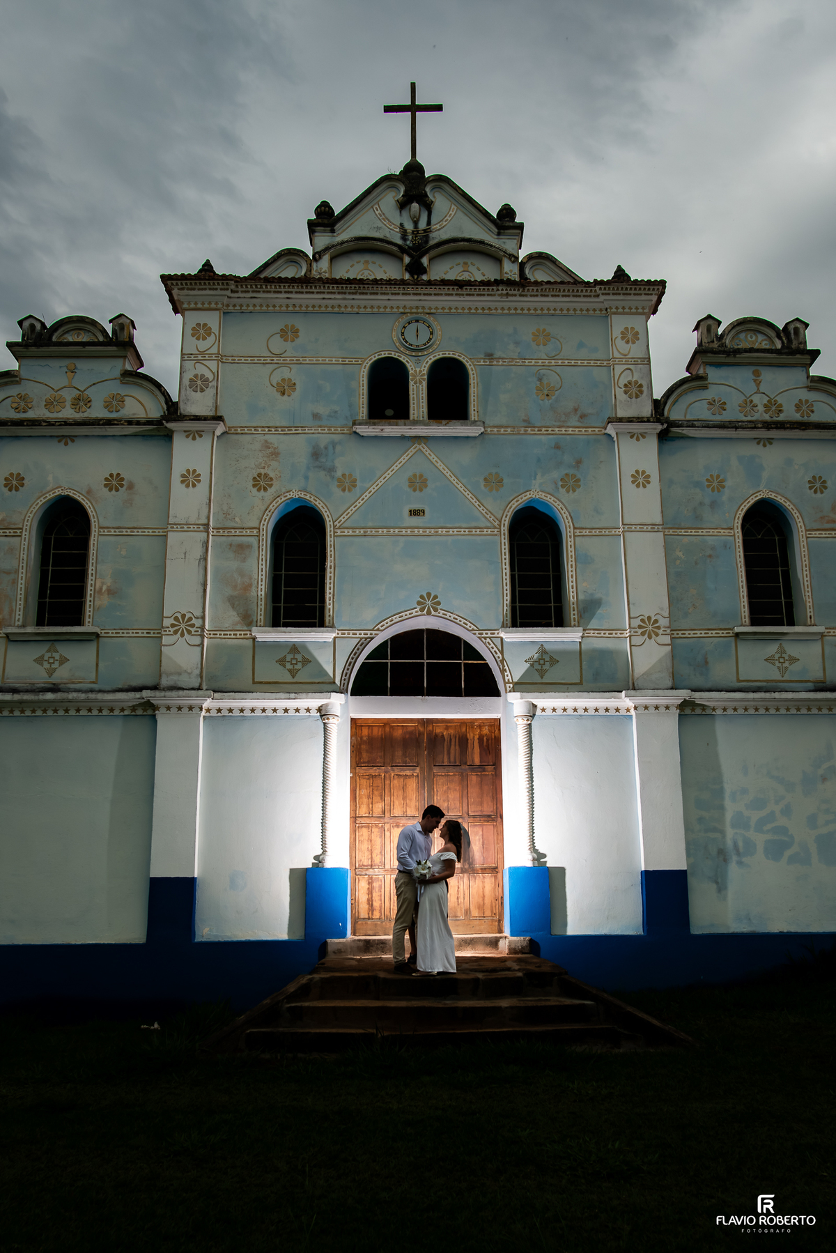 Casal fotografado diante da fachada histórica da Igreja Nossa Senhora da Conceição durante pré-wedding em Itamonte MG.