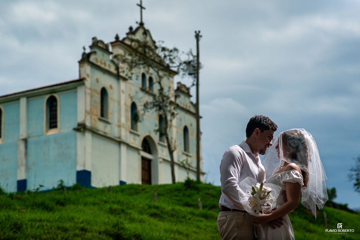 Ensaio pré-wedding de Ivanna e Luis Gustavo com véu e buquê diante da Igreja Nossa Senhora da Conceição em Itamonte MG.
