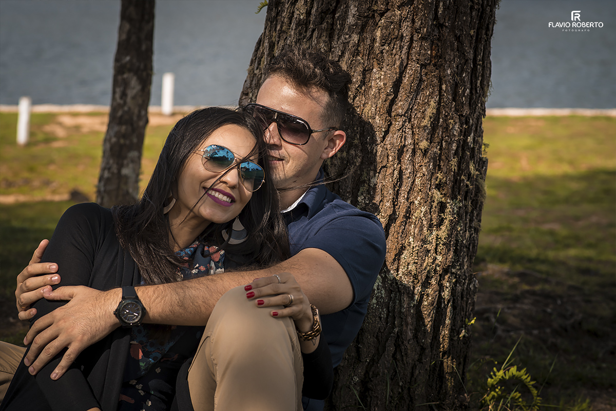 Casal sentado encostado na árvore durante o Ensaio de Casal em Campos do Jordão-SP
