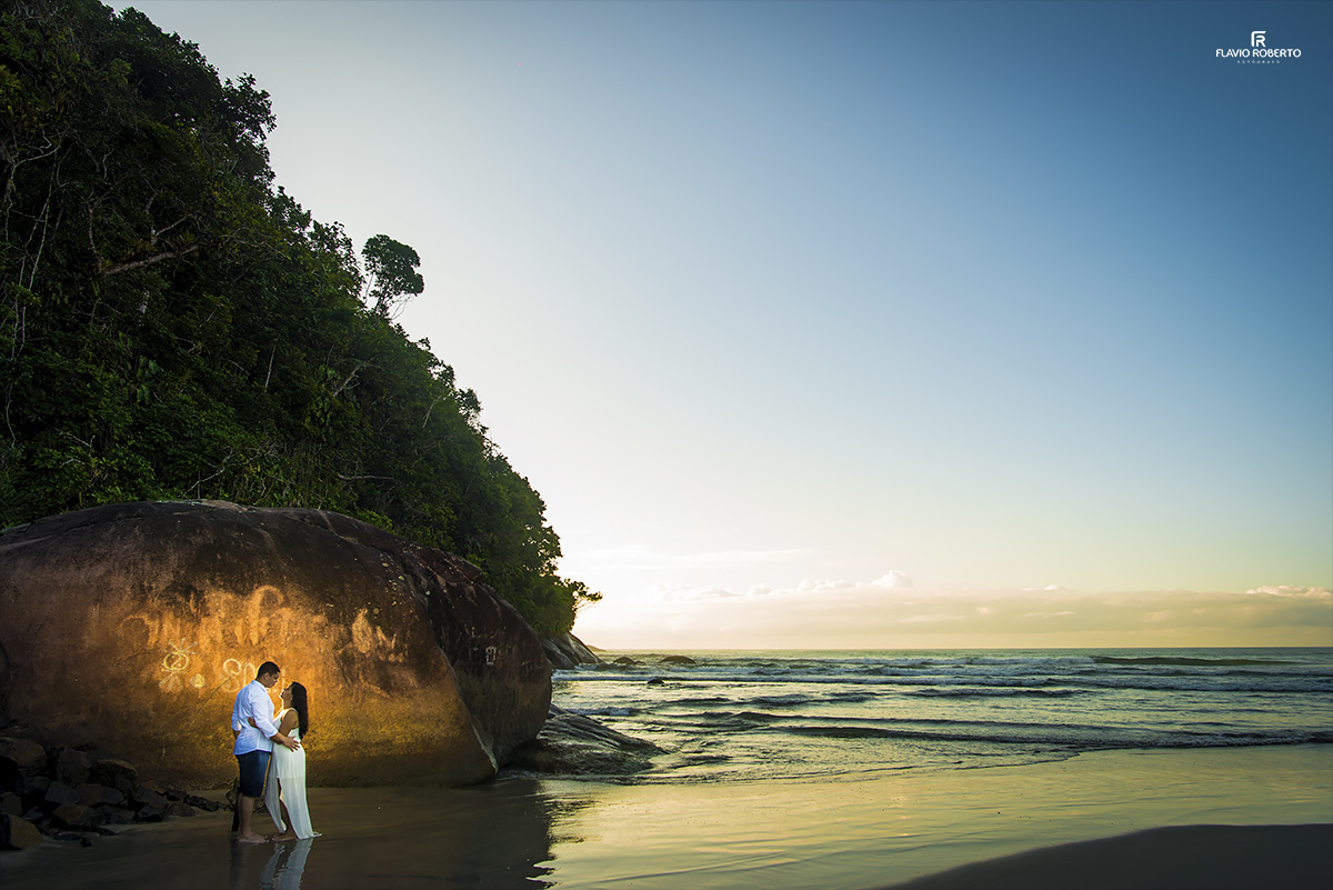 namorados conversando nas pedras ao lado da praia em Ubatuba