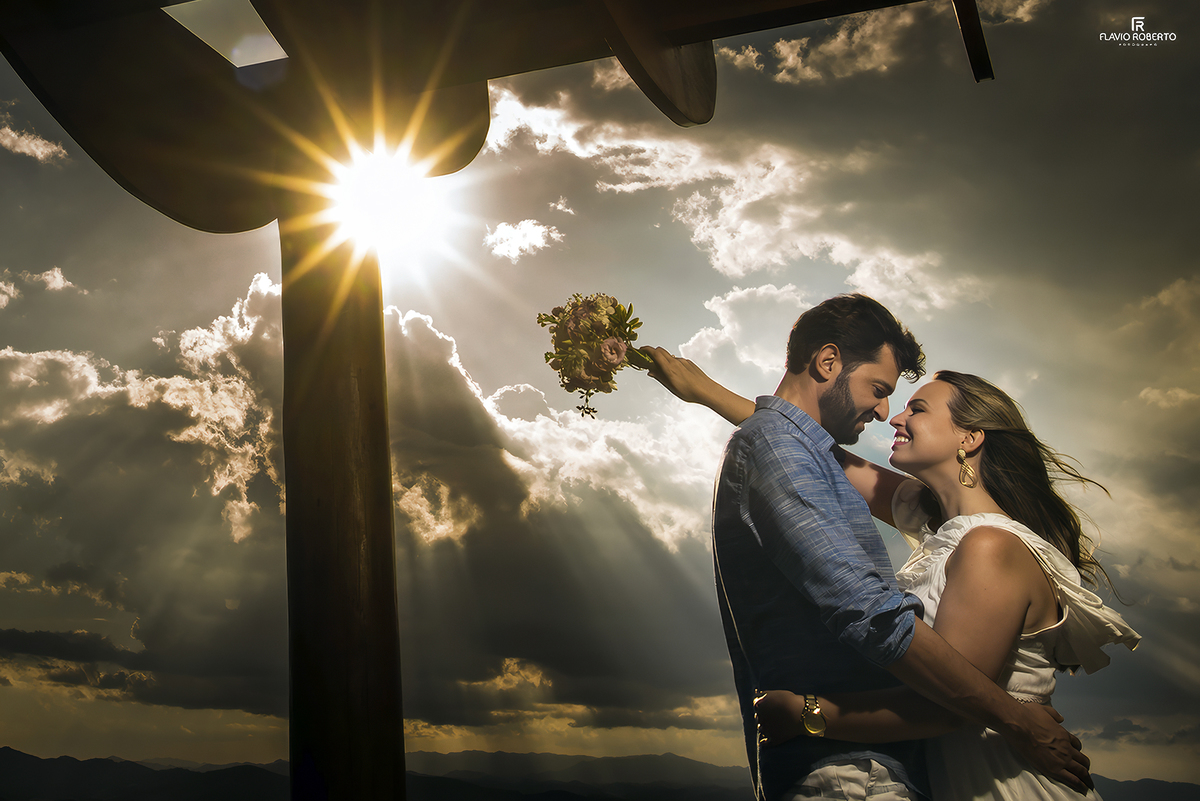 Casal abraçado diante do pôr do sol nas montanhas de Cunha