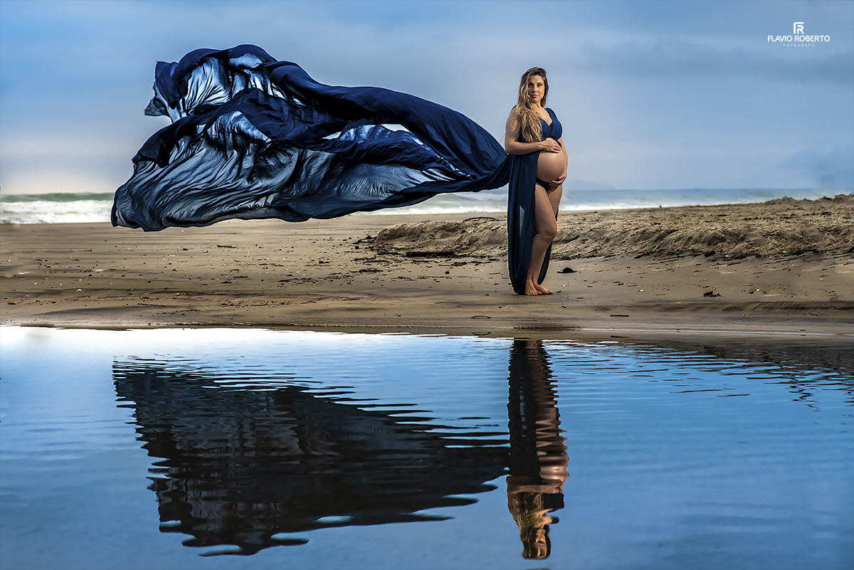 gestante na praia com um véu enorme voando no Ensaio de Gestante em Ubatuba