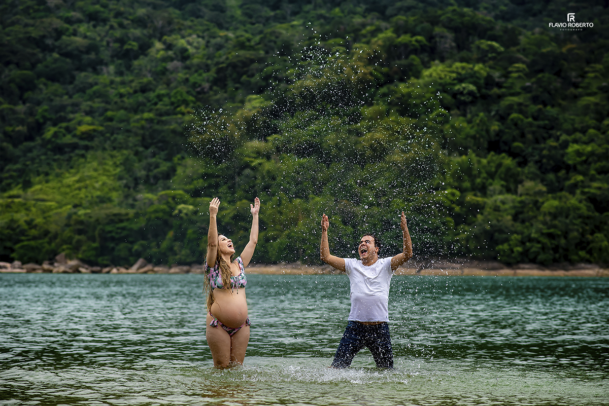 casal jogando água para o céu celebrando a gestação do seu filho que vai nascer no Ensaio de Gestante em Ubatuba