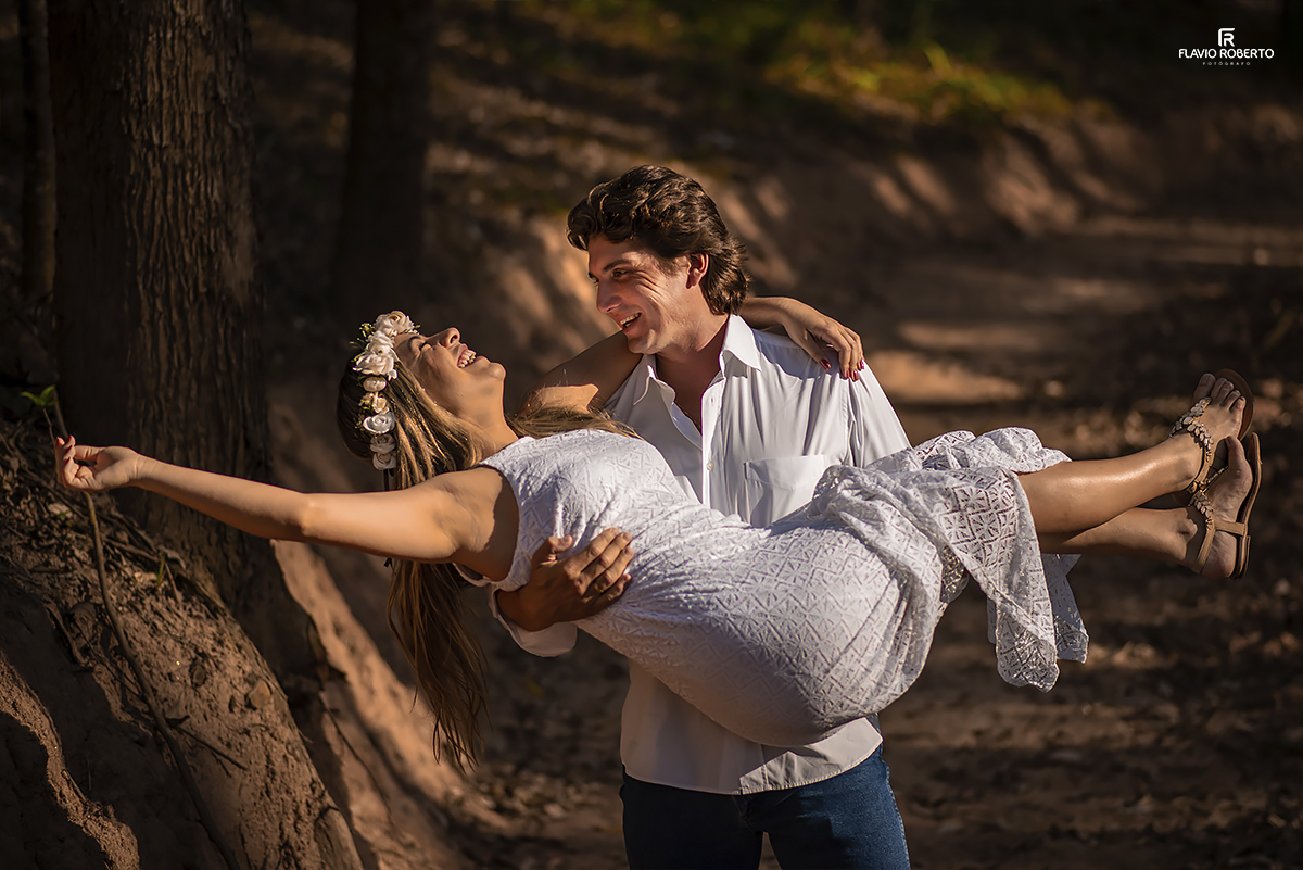 Noivo levando sua noiva no colo na trilha da fazenda