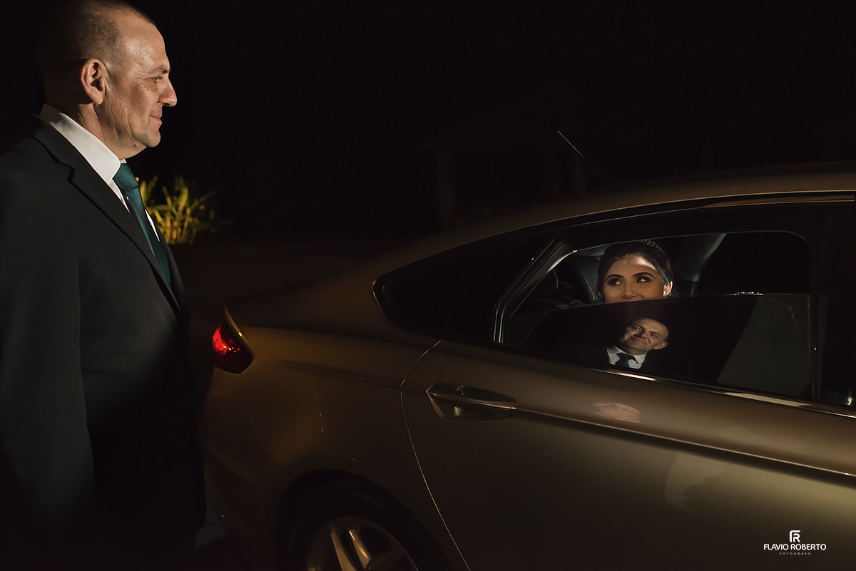 Pai da Noiva recebendo ela no carro. reflexo do seu rosto com o rosto da noiva