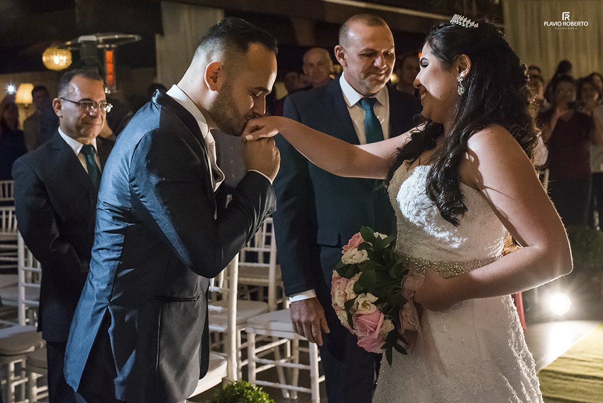 Noivo recebendo a noiva com um beijo na mao. 