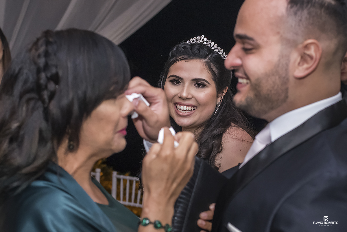noiva olhando o noivo enxugando as lágrimas da sua mamae.