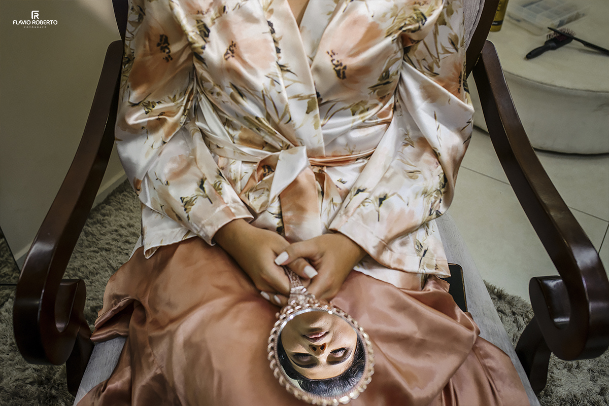 Noiva se olhando no espelho durante o making off