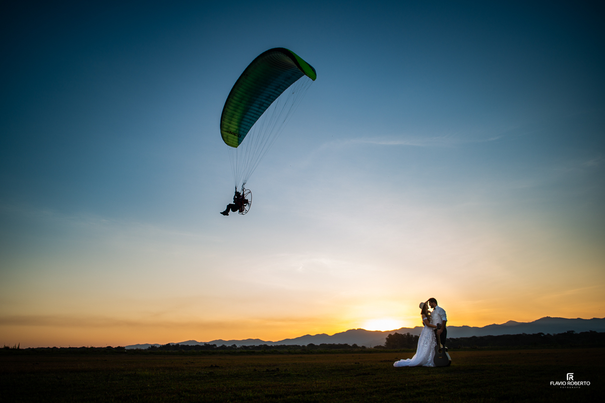 Noivos se beijando com paraglider