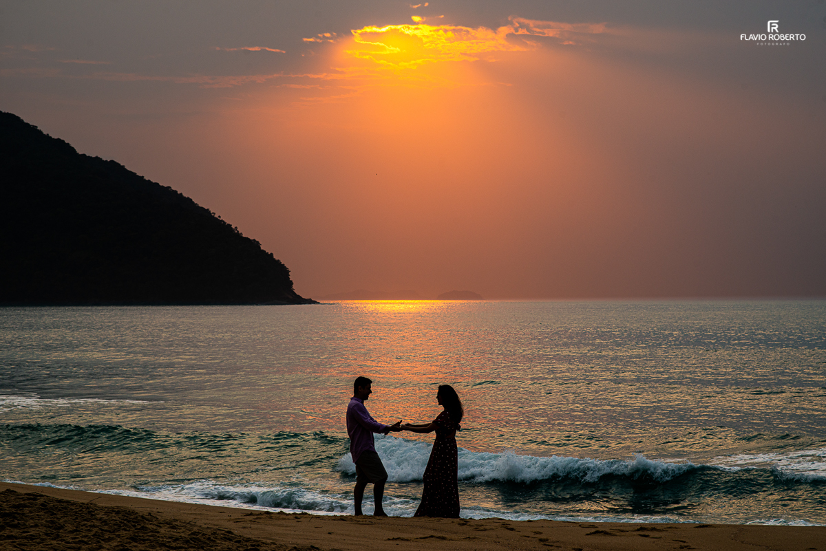 Casal namorando com um lindo nascer do sol na Praia Vermelha