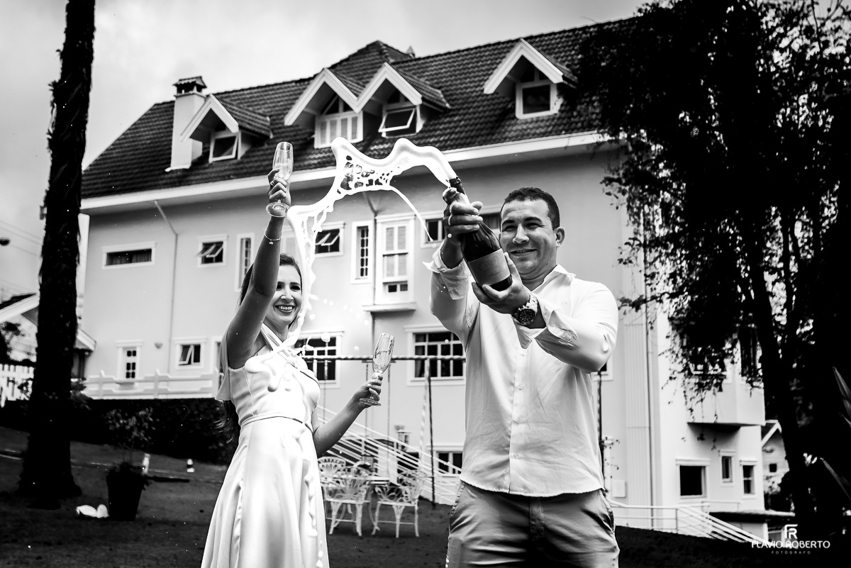 Noivos estourando Champagne na Pousada Dom Alfredo José em Ensaio em Campos do Jordão