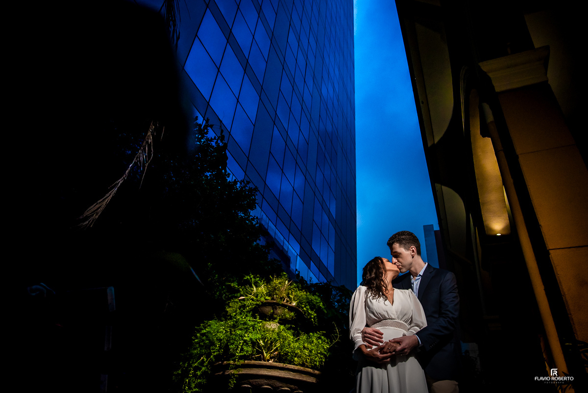 Casal se beijando no anoitecer azul entre os edifícios da cidade de Sao Paulo do lado da Paróquia Sao Luiz Gonzaga em SP