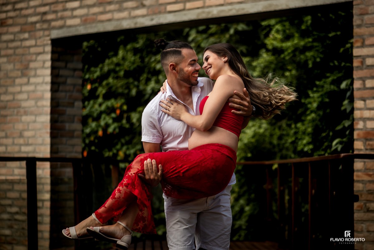 Esposo carregando sua mulher gravida no colo durante ensaio de gestante em Taubaté.