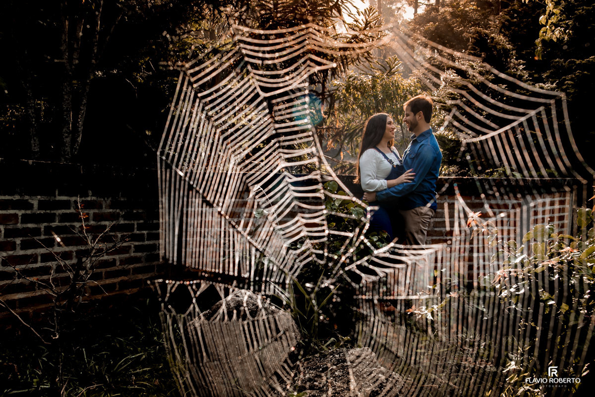 Noivos abraçados atrás de uma teia de aranha em pre wedding em Santo Antônio do Pinhal.