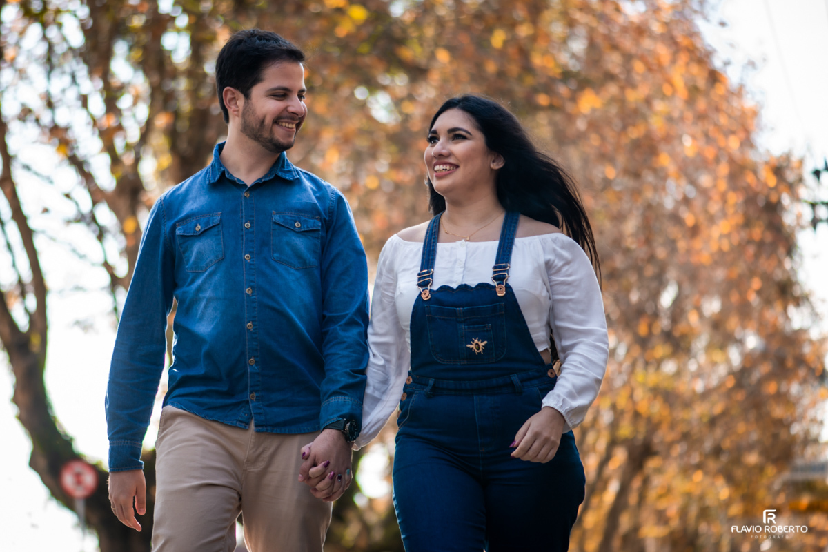 Casal de namorados caminhando em Campos do Jordão durante o Ensaio Pré Wedding, com as árvores nas cores de outono.