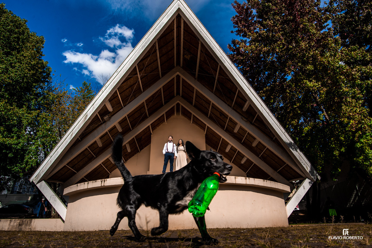 Casal de Noivos namorando em Centro de Eventos de Campos do Jordão durante Pre Wedding, com cachorro passando na frente deles.