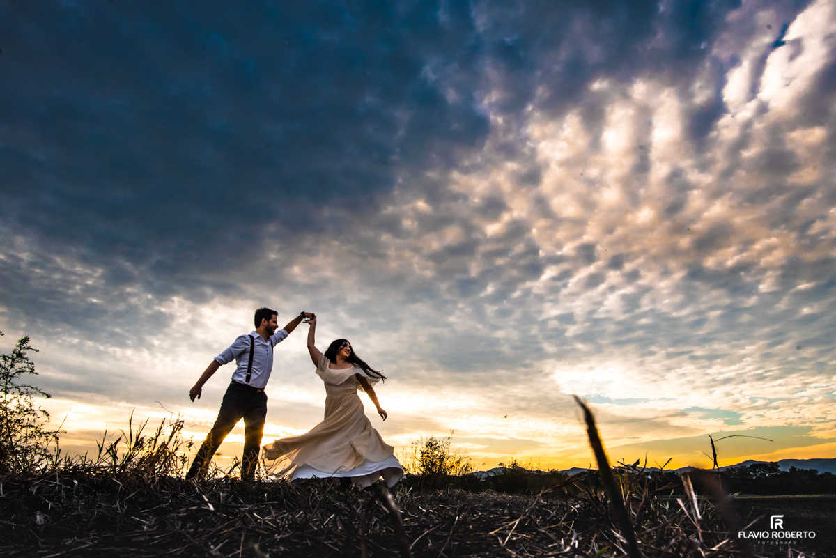 Noivos brincando durante o pôr do sol em Ensaio Pré Wedding em Campos do Jordão.